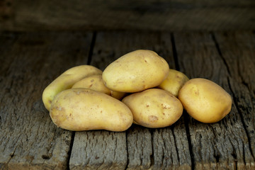 Fresh potatoes on an old wooden table