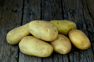 Fresh potatoes on an old wooden table