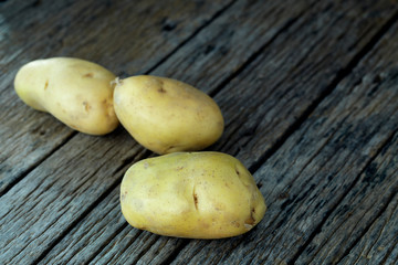 Fresh potatoes on an old wooden table