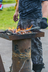 Smith warms up the tool in the roaster with burning coals