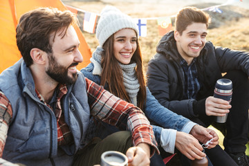 Fototapeta premium Group of cheerful young friends camping outdoors