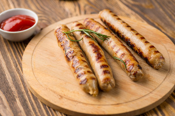 Grilled sausages with sauce ketchup on a wooden table