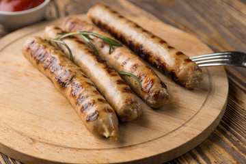 Grilled sausages with sauce ketchup on a wooden table