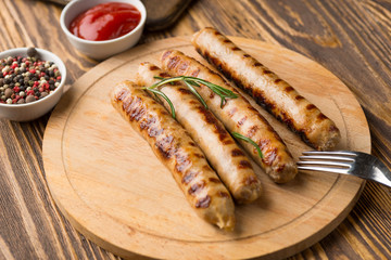 Grilled sausages with sauce ketchup on a wooden table