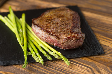 Meat table : grilled beef fillet with asparagus on wooden table