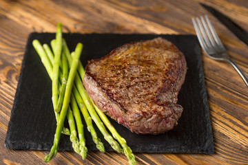 Meat table : grilled beef fillet with asparagus on wooden table