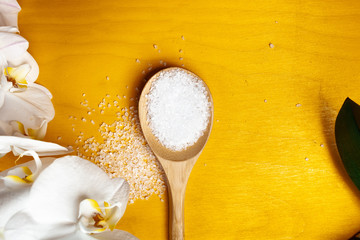  beautiful spa composition with orchid flower, salt in a spoon on a yellow background.