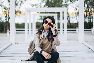 Obraz premium Pretty long hair brunette girl in sunglasses relaxing outdoor.