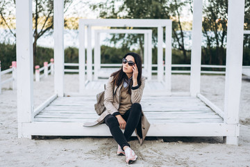 Pretty long hair brunette girl in sunglasses relaxing outdoor.