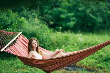 young woman reading a book in hammock