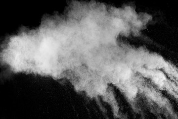 Freeze motion explosion of white powder on a black background.Stopping the movement of white dust on dark background.