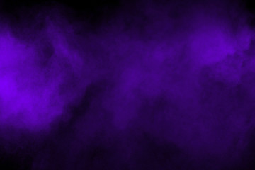 Freeze motion explosion of purple powder dust on a black background. By throwing blue talcum  out...