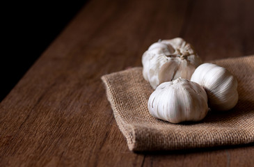 close up garlic cloves on sackcloth and wooden table