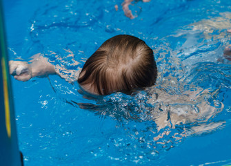baby swims in the pool under water