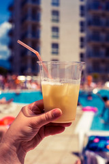 A glass of cocktail on the background of the pool