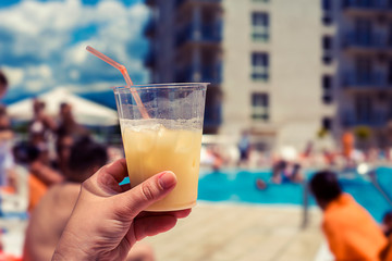 A glass of cocktail on the background of the pool