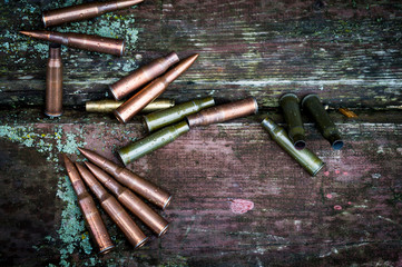 old casings and cartridges on wooden background, vignetting