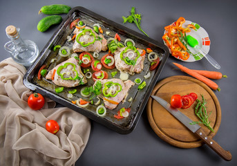 Raw chicken with ingredients for cooking on a gray background. Selective focus