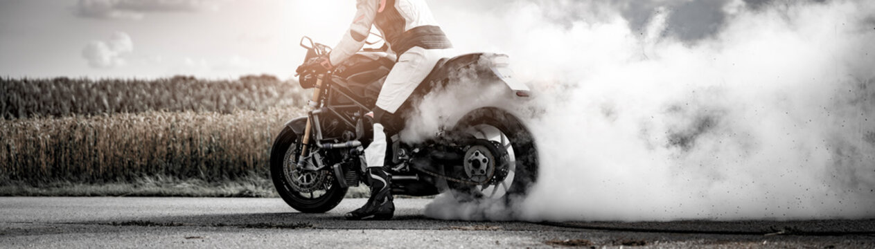 wilder Motorradfahrer l&auml;sst die Reifen bei einem Burnout durchdrehen und macht einen Donut