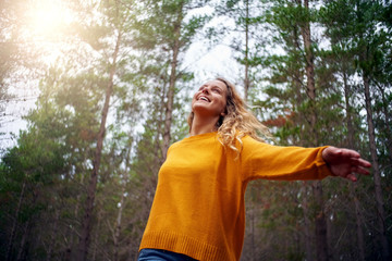 Beautiful happy blonde young woman dancing in forest - Powered by Adobe