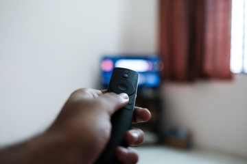 Watching tv and using remote control  to change the channel 
