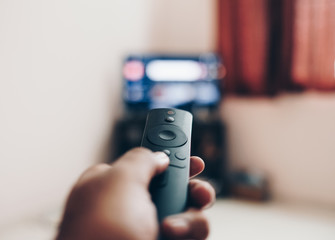 Watching tv and using remote control  to change the channel 