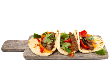Three Fajitas on a Marble Serving Board on a White Background
