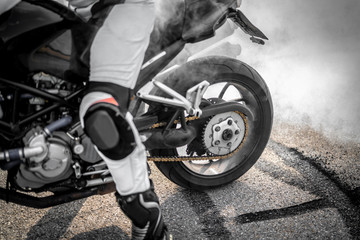 wilder Motorradfahrer lässt die Reifen bei einem Burnout durchdrehen und macht einen Donut - obrazy, fototapety, plakaty