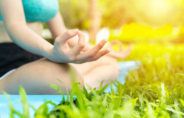 Close up hand of teenage girl or young woman doing exercise or Practicing yoga outdoor, vital and meditation at fitness lifestyle club midst of peaceful nature. zen, health,international yoga day,Asia