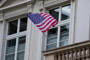 Flag of the United States of America on the wall of the building. Flag evolving in the wind on...