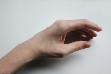 Woman's skinny hand in front of grey background