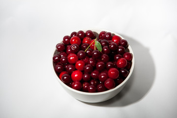 white plate with red cherry on white background