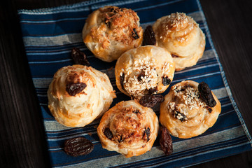  puff buns with raisins on a blue background