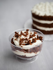 portioned chocolate cake with white cream in a cup