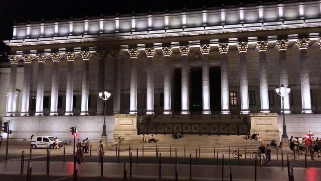 Left to right slow timelapse of the Cour d'assise, Courts of Appeal, Lyon, floodnight by night with the busy city life