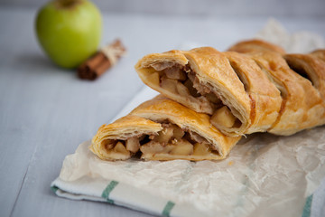 strudel with apple and cinnamon on a light towel, light background