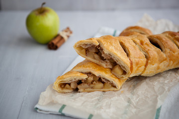 strudel with apple and cinnamon on a light towel, light background
