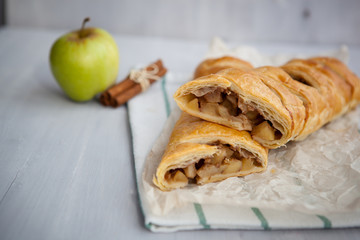 strudel with apple and cinnamon on a light towel, light background