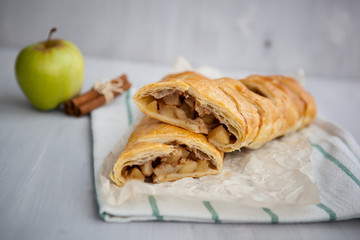 strudel with apple and cinnamon on a light towel, light background
