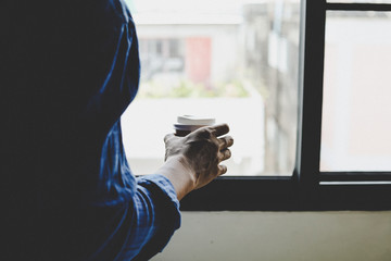 Business man holding coffee cup and standing thinking creative work at homework.