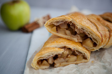 strudel with apple and cinnamon on a light towel, light background