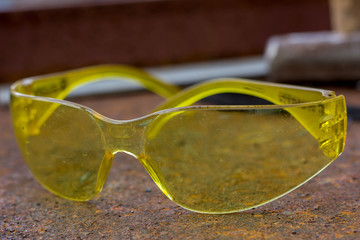 Yellow safety glasses for dirty work. Eye protection against small debris in the eyes.