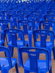 Long blue plastic chairs arranged in long rows