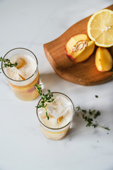 Fresh peach lemonade on light marble background. Top view