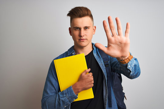 Young student man wearing denim shirt backpack notebook over isolated white background with open hand doing stop sign with serious and confident expression, defense gesture