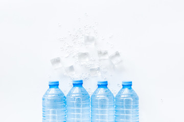 Plastic bottles with pure water and ice on white background top view space for text