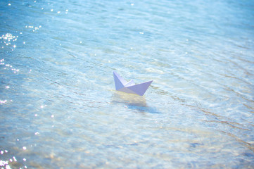 paper boat on the waves of blue water