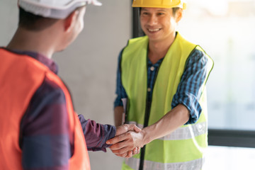 Group of officer teamwork is happy and shake hands to celebrate in success of finish in job planning about home building construction project