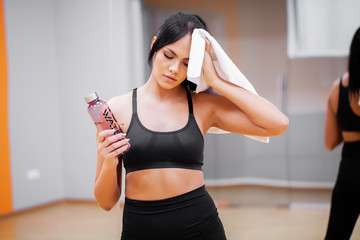 Young woman drink clean water in fitness gym