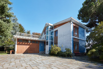Villa with garden, elevator and garage in a sunny summer day, clear blue sky in Italy